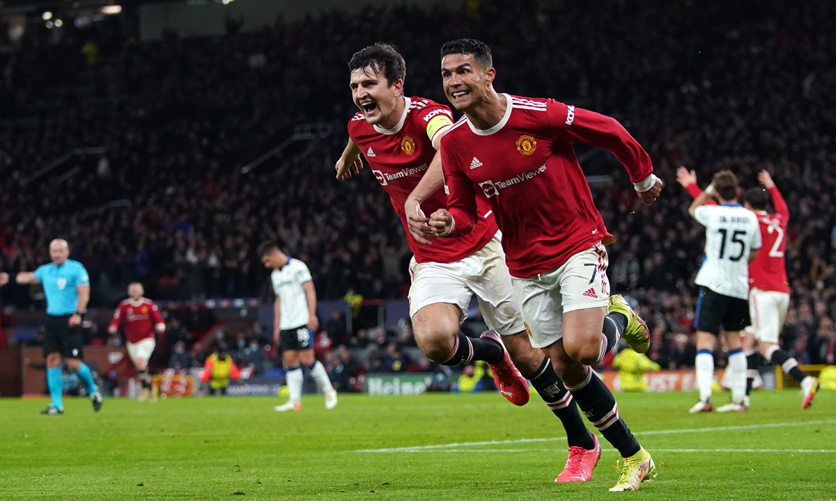Manchester United's Cristiano Ronaldo (second left) celebrates scoring their side's third goal of the game with Harry Maguire during the UEFA Champions League, Group F match at Old Trafford, Manchester. Picture date: Wednesday October 20, 2021.