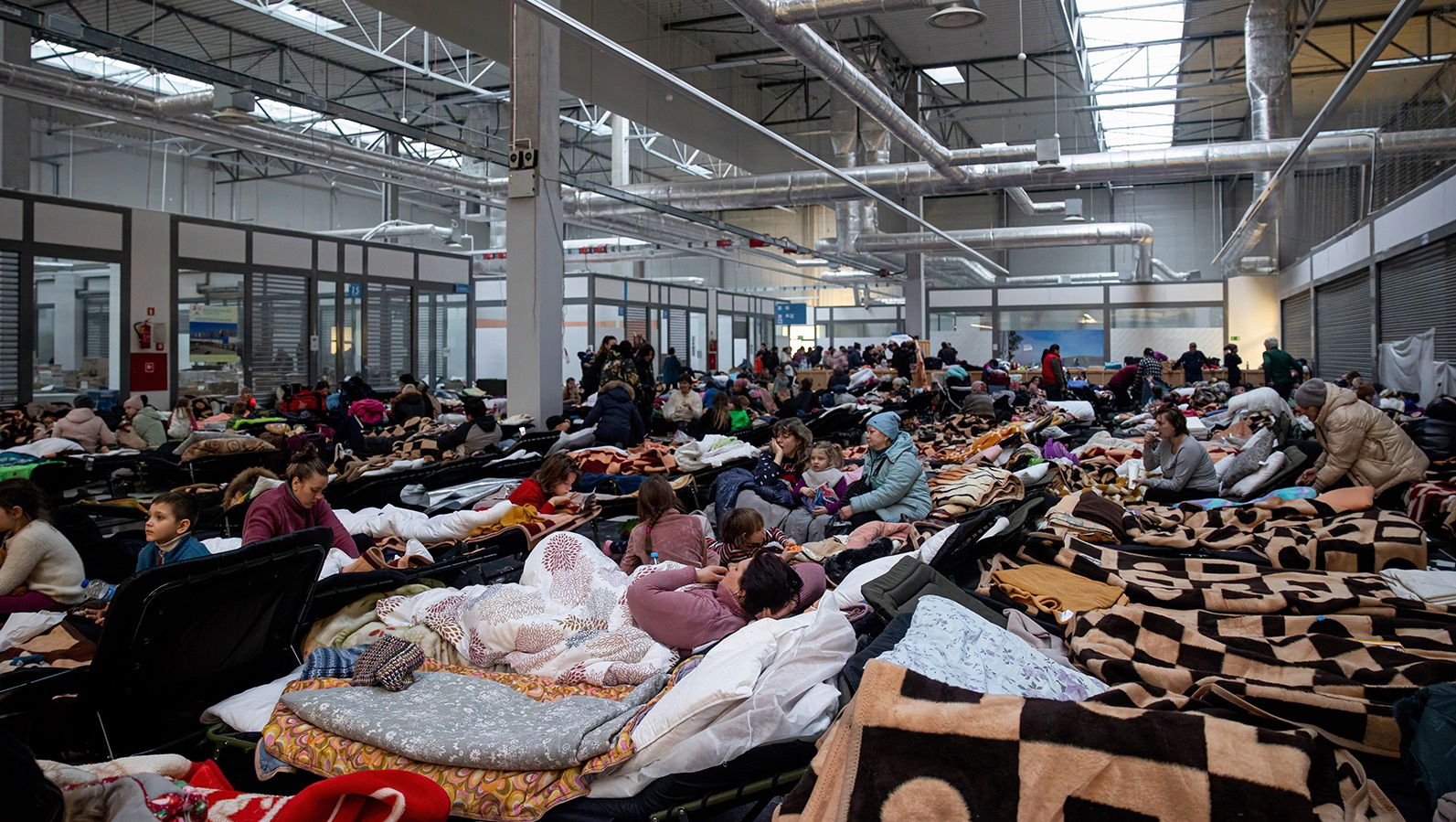 KORCZOWA, POLAND - 2022/03/07: Refugees are resting inside the reception area.
A temporary reception area has been set up at a warehouse at Korczowa to cope with hundreds of thousands of Ukrainian refugees fleeing through the Korczowa-Krakowiec border. (Photo by Hesther Ng/SOPA Images/LightRocket via Getty Images)