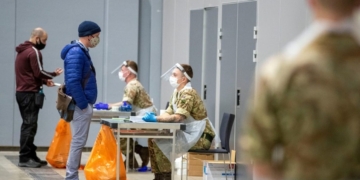 Soldiers talk to people at The Exhibition Centre, which has been set up as a testing centre as part of the mass coronavirus disease (COVID-19) testing, in Liverpool, Britain, November 6, 2020. Peter Byrne/PA Wire/Pool via REUTERS