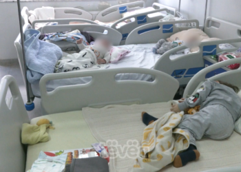 Nga dy fëmijë në një shtrat po marrin trajtimin shëndetësor në Klinikën e Pediatrisë në QKUK